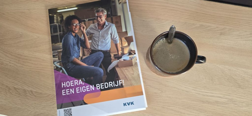 Tijdschrift over een eigen bedrijf naast een kop koffie op tafel